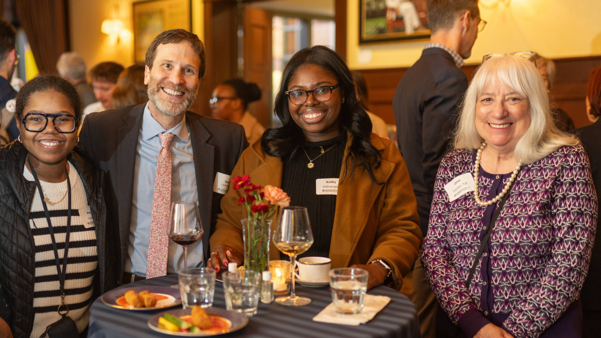 Students and donors smile and pose at a reception.